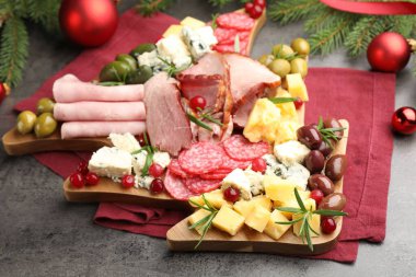 Lezzetli Noel Şarküteri tahtası. Atıştırmalıkları, köknar dalları ve gri desenli masalarda takılar. Yakın plan.