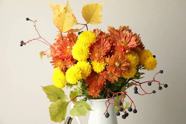 Sonbahar atmosferi. Güzel çiçekli vazo ve arka planda böğürtlen, yakın plan.
