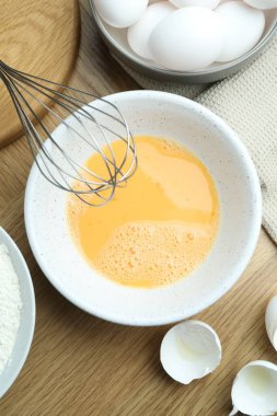 Kavanozda çırpılmış yumurtalar ve tahta masada çırpılmış çırpılmış çırpılmış çırpılmış.