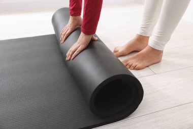 Yoga stüdyosunda hasırları açan kadın, yakın çekim.