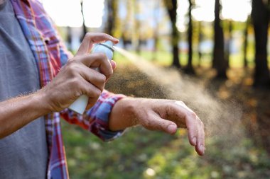 Parkta koluna kene püskürten bir adam, yakın plan. Metin için boşluk