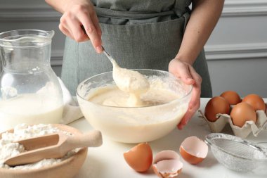 Beyaz masada hamuru hazırlayan kadın, yakın plan.