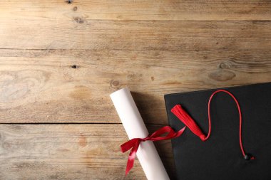 Mezuniyet şapkası ve diploması tahta masada, düz yatıyordu. Metin için boşluk