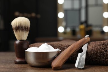 Traş fırçası, köpük, ustura ve havlu berber dükkanında, yakın plan.