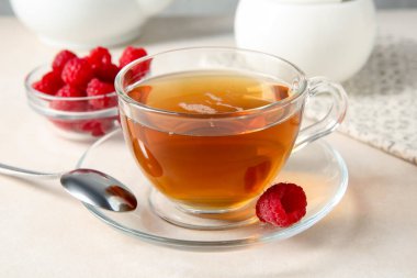 Lezzetli çay ve ahududular beyaz masada, yakın plan.