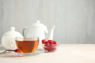 Beyaz masada servis edilen lezzetli çay ve ahududu. Metin için boşluk