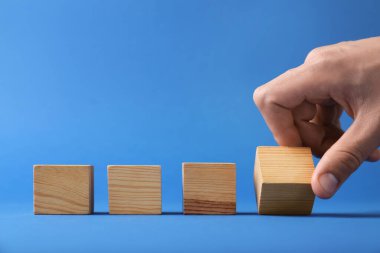 Mavi arka planda tahta küpleri olan adam, yakın plan. Metin için boşluk