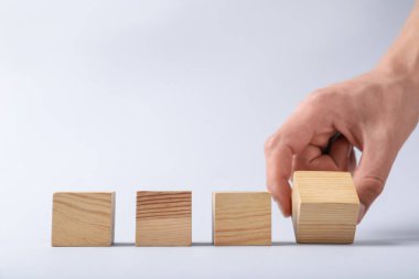 Hafif arka planda tahta küpleri olan adam, yakın plan. Metin için boşluk