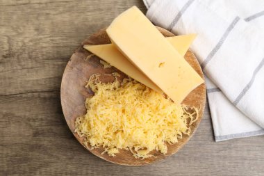 Tahta masanın üstünde rendelenmiş ve peynir parçaları, üst manzara.