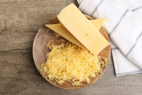 Tahta masanın üstünde rendelenmiş ve peynir parçaları, üst manzara.