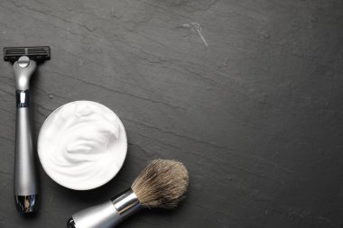 Siyah arka planda farklı berber aletleri, düz yatış. Metin için boşluk