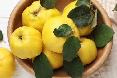 Beyaz ahşap masadaki yaprak dolu taze ayva yaprakları.