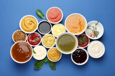 Mavi arka planda farklı soslar ve otlar var.