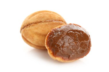 Lezzetli fındık şekilli kurabiyeler haşlanmış konsantre süt beyaz üzerinde izole edilmiş.