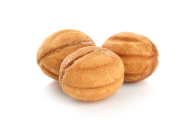 Lezzetli fındık şekilli kurabiyeler haşlanmış konsantre süt beyaz üzerinde izole edilmiş.