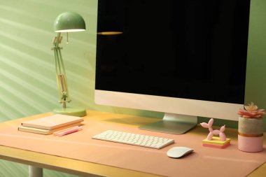 Ofisinde bilgisayar ve pembe hasırlı şık bir iş yeri, yakın plan.