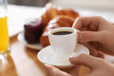 Yatakta kahvaltı yapan bir adam, yakın plan. Otel oda servisi.