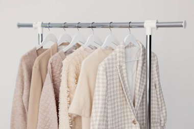 Arka planda askıda asılı farklı kıyafetler, yakın plan