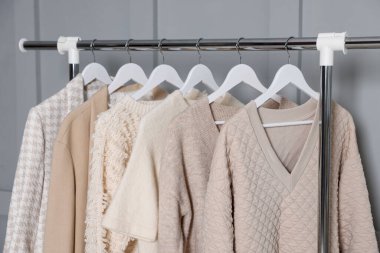 Gri duvarın yanında asılı farklı elbiseler.