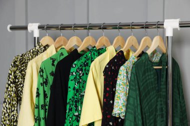 Gri duvarın yanında asılı farklı elbiseler.