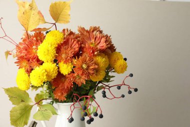 Sonbahar atmosferi. Güzel çiçekli vazo ve arka planda böğürtlen, yakın plan. Metin için boşluk