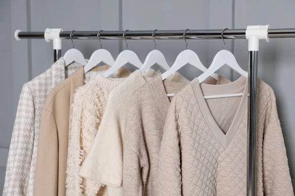 Gri duvarın yanında asılı farklı elbiseler.