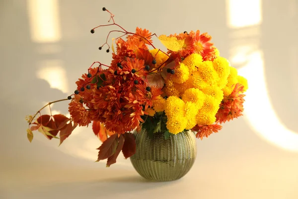 Sonbahar atmosferi. Güzel çiçekli vazo ve bej arkaplanda böğürtlen.