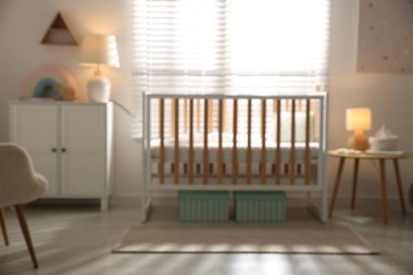 Bebek odası, beşik ve şifoniyerle bulanık görünüyor. İç tasarım