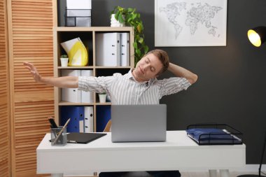 Masada boynunu uzatan genç iş adamı.