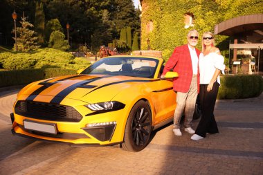 Modern Cabriolet yakınlarında güneş gözlüklü şık bir çift.