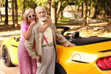 Modern Cabriolet yakınlarında şık bir yaşlı çift.