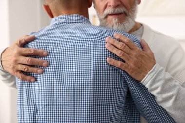 Baba ve oğul birbirlerine sarılıp yakınlaşıyorlar.