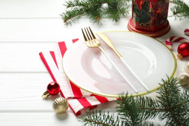 Beyaz ahşap arka planda Noel dekoru olan şenlik masası, yakın plan.