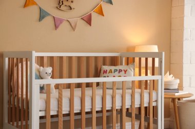 Beşik, masa, lamba ve dekorlu şık bir bebek odası. İç tasarım