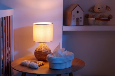 Geceleri bebek odasında beşik, lamba, oyuncaklar ve masa