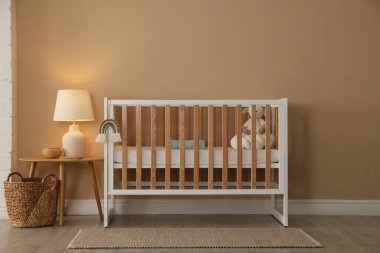 Beşik, masa ve dekorlu şık bir bebek odası. İç tasarım