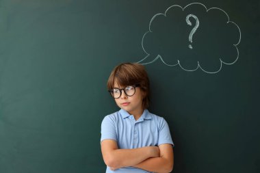 Okula dönelim. Düşünce baloncuğu ve soru işareti olan tahtaya yakın bir çocuk.