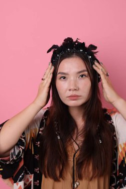 Pembe arka planda tüylü şaman kadın.