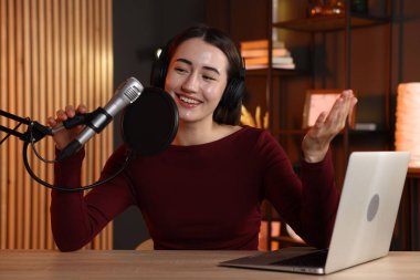 Podcast sunucusu stüdyoda talk show kaydediyor.