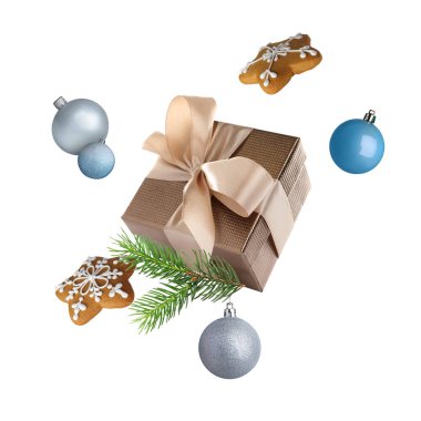 Noel ya da yeni yıl kutlaması. Hediye kutusu, kurabiyeler ve beyaz arka planda uçuşan şenlikli dekor