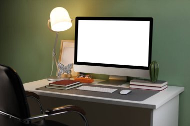 Ofisinde bilgisayar ve gri paspas olan şık bir iş yeri.