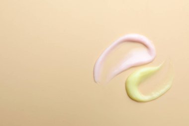 Bej arka planda farklı kozmetik ürünlerinden örnekler. Metin için boşluk