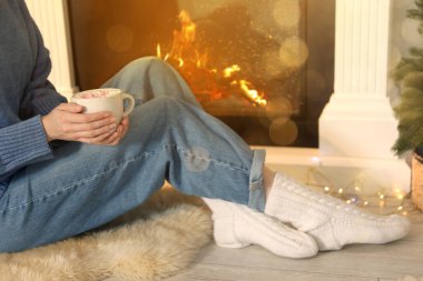 Evde şöminenin yanında nefis sıcak kakaolu bir kadın, yakın plan. Noel titreşimleri