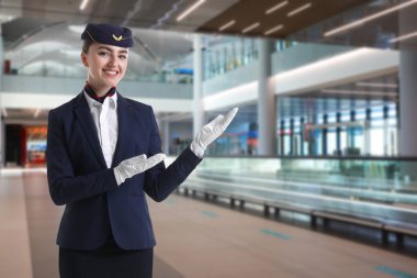 Havaalanı terminalinde gülümseyen üniformalı hostes.