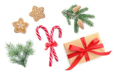 Noel şeker kamışları, zencefilli kurabiyeler, hediye kutusu ve beyaz üzerine izole edilmiş köknar ağacı dalları.