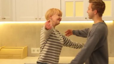 Anne ve oğul mutfakta birbirlerine sarılıyorlar.