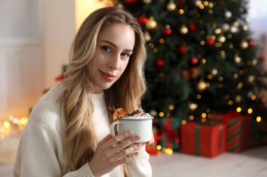 Güzel bir kadın krem şantili, tarçınlı ve portakal dilimli sıcak kakao içiyor. Mesaj için yer var. Noel sezonu