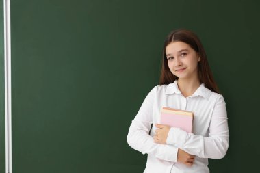 Okula dönelim. Kara tahtanın yanına kitap koyan öğrenci, metin için boşluk
