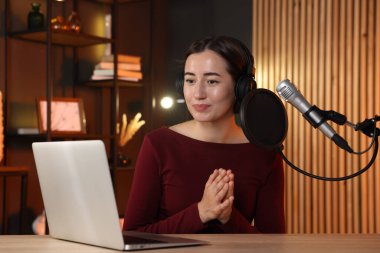 Podcast sunucusu stüdyoda talk show kaydediyor.