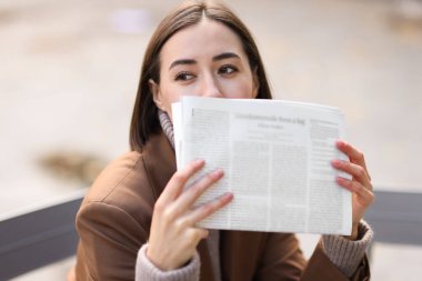 Bulanık arka planda gazetesi olan takım elbiseli güzel kadın.